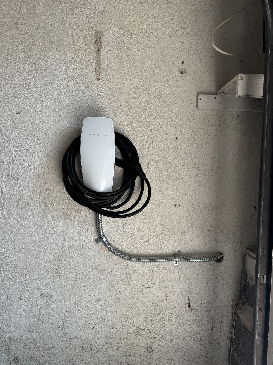 Hardwired Tesla Wall Connector mounted in a clean garage by Fuse Electric in Ho-Ho-Kus, NJ