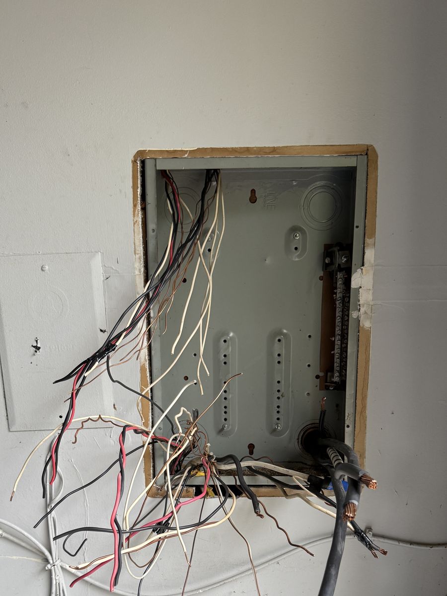 Before: an old electrical panel removed during a Fuse Electric panel replacement in Township of Washington, NJ, with feeder and branch wiring exposed in the open wall cavity